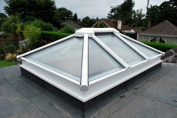 White-framed pyramid roof lantern installed on a flat felt roof