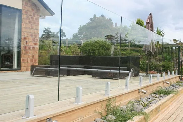 Frameless glass balustrade fixed with stainless spigot standoffs along a timber deck