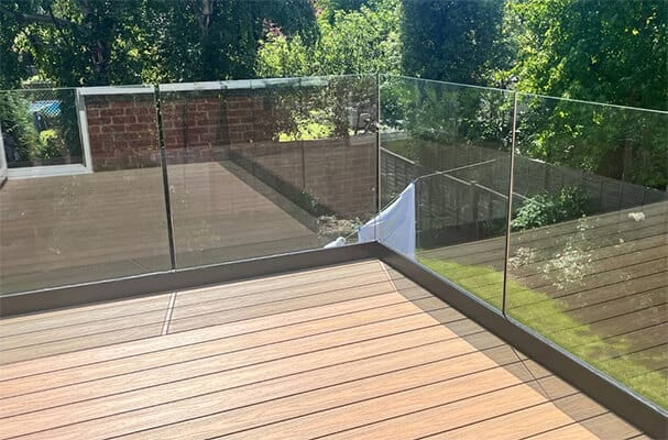 Frameless glass balustrade in a base channel around a timber roof deck