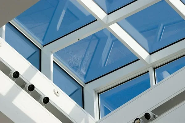 Grid of blue-tinted skylight panels seen from inside a bright interior