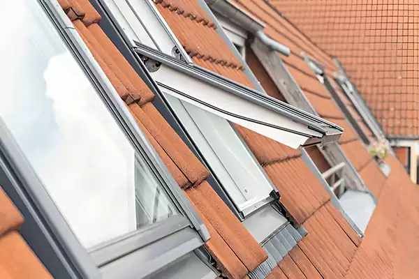 Open pitched roof window with a white frame and raised venting sash