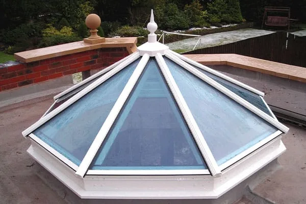 Octagonal white-framed roof lantern with decorative finial on a flat roof