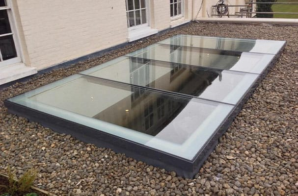 Multi-panel flat rooflight with laminated safety glass on a gravel roof
