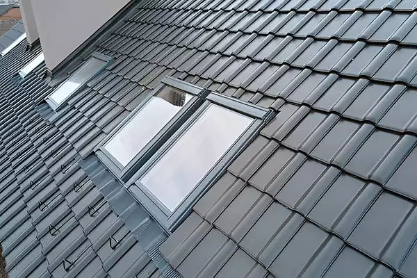 Two matching pitched roof windows installed side by side in a tiled roof