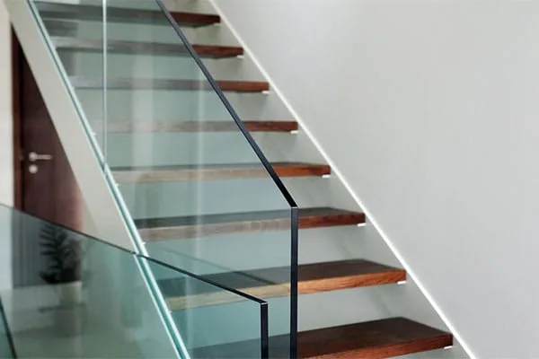 Frameless glass balustrade with a slim base channel alongside an oak staircase