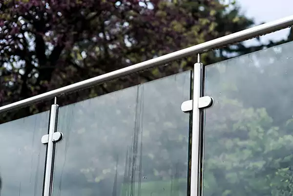 Outdoor glass balustrade with stainless steel clamps and handrail